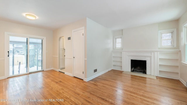 unfurnished living room with a wealth of natural light and light wood-type flooring