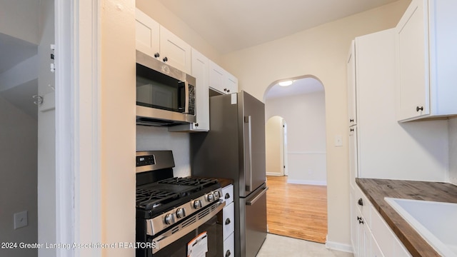 kitchen with white cabinets, appliances with stainless steel finishes, and sink