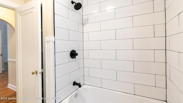 bathroom with tiled shower / bath and hardwood / wood-style floors