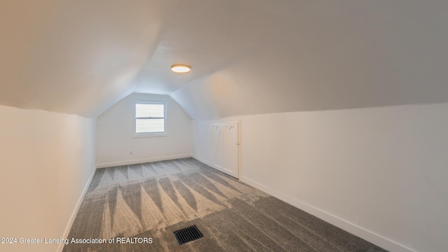 bonus room with lofted ceiling and carpet floors