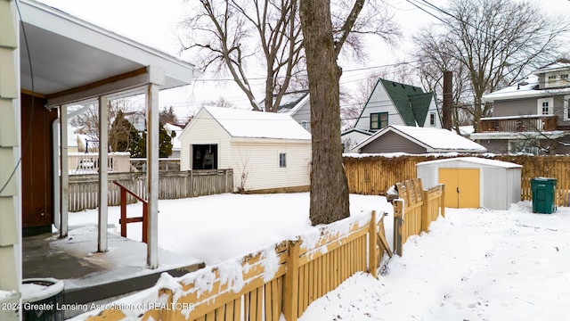 yard covered in snow with a storage shed