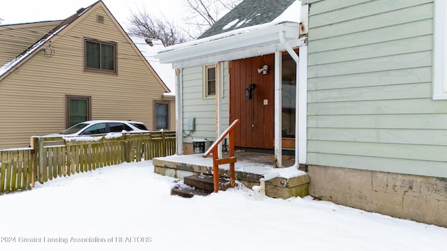 view of snow covered back of property