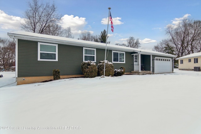 view of front of property with a garage and central AC