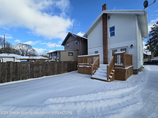 snow covered property with a wooden deck