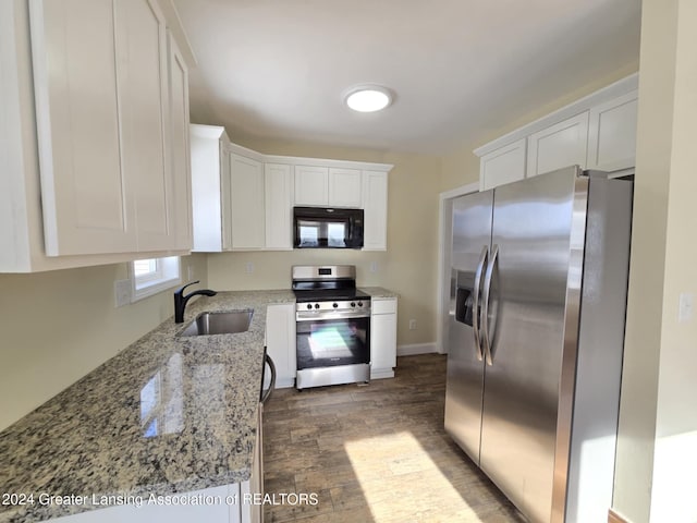 kitchen featuring dark hardwood / wood-style floors, sink, white cabinetry, stainless steel appliances, and light stone counters