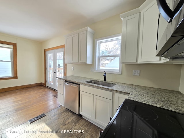 kitchen with light stone countertops, white cabinetry, dishwasher, and sink