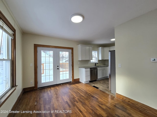 kitchen with white cabinets, appliances with stainless steel finishes, and a healthy amount of sunlight