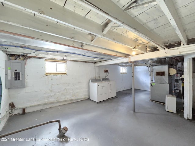 basement with gas water heater, washing machine and clothes dryer, and electric panel