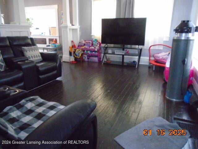 living room featuring ornate columns and dark hardwood / wood-style floors