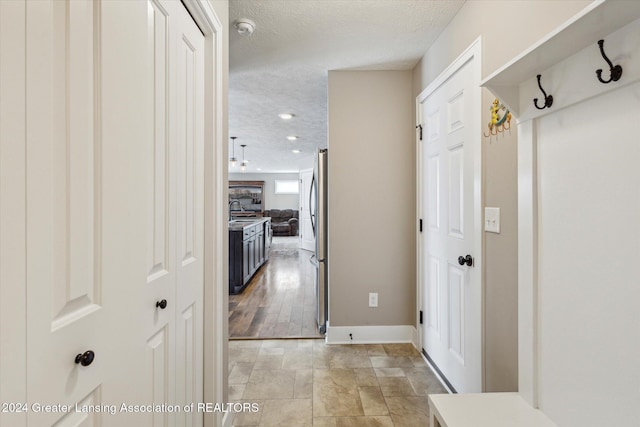 hall featuring a textured ceiling and sink