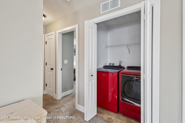 washroom with a textured ceiling, light colored carpet, and independent washer and dryer