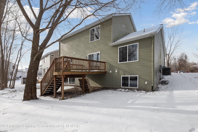 snow covered house featuring a wooden deck and central air condition unit