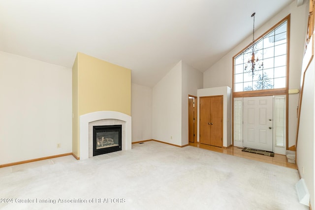 unfurnished living room featuring light carpet, a fireplace, high vaulted ceiling, and a notable chandelier