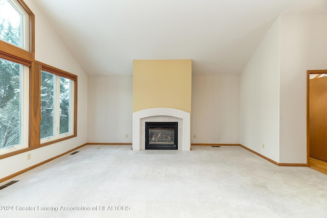 unfurnished living room featuring a fireplace, light colored carpet, and vaulted ceiling