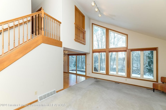 additional living space with carpet, a wealth of natural light, and an inviting chandelier