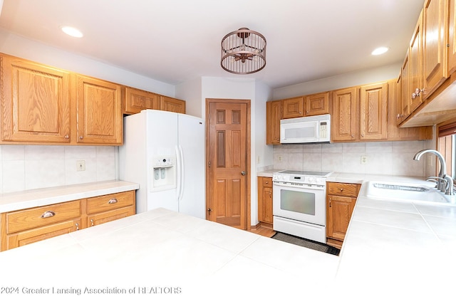 kitchen featuring white appliances, tile countertops, and decorative backsplash