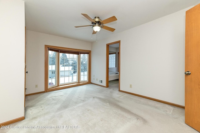 carpeted spare room with ceiling fan