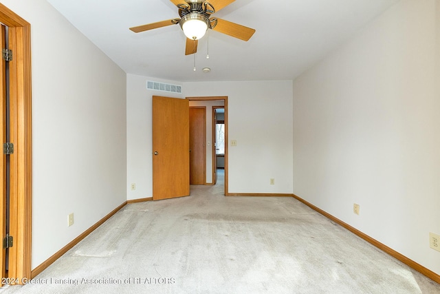 spare room featuring ceiling fan and light colored carpet