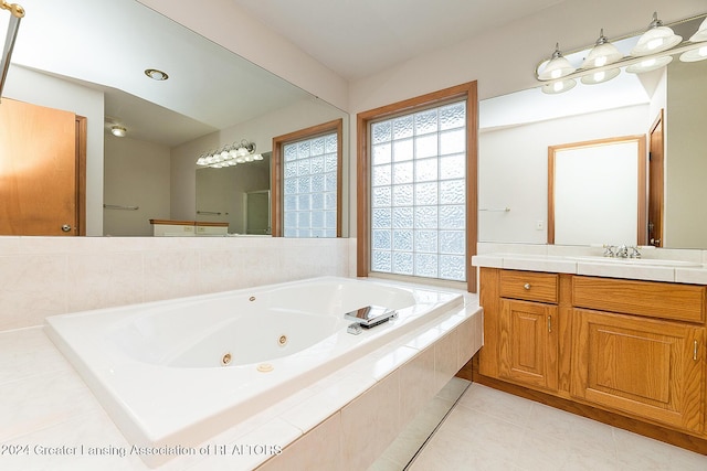 bathroom featuring tile patterned flooring, tiled tub, and vanity