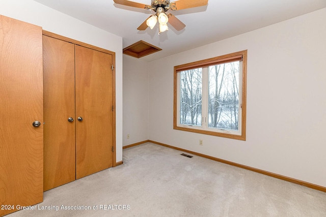 unfurnished bedroom with ceiling fan, a closet, and light carpet