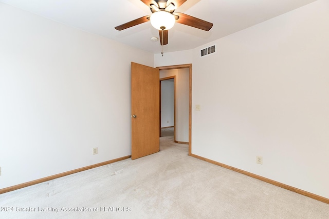 carpeted spare room featuring ceiling fan