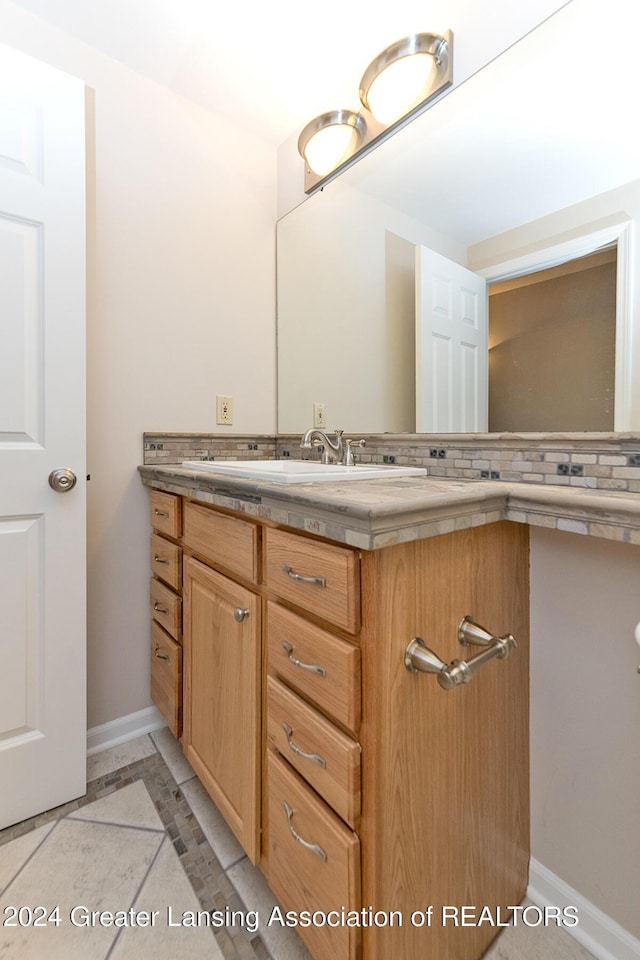 bathroom with backsplash, tile patterned flooring, and vanity