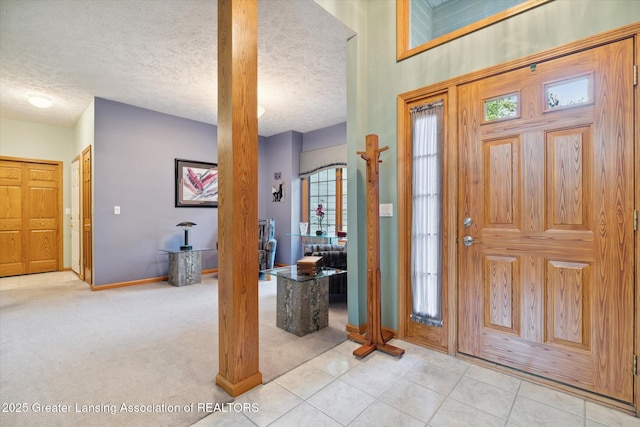 foyer featuring light carpet and a textured ceiling