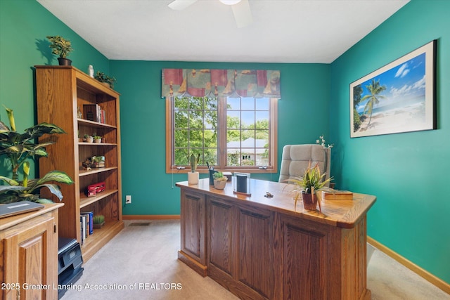 carpeted office space featuring ceiling fan