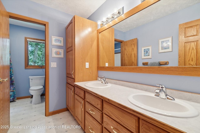 bathroom featuring vanity, a textured ceiling, and toilet