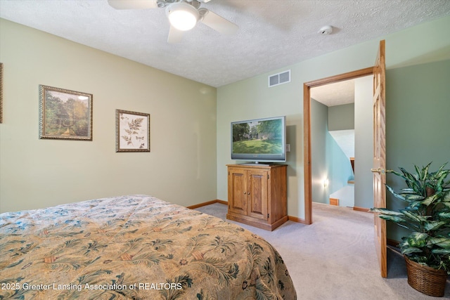 carpeted bedroom with ceiling fan and a textured ceiling