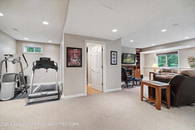 workout room with light carpet and a textured ceiling