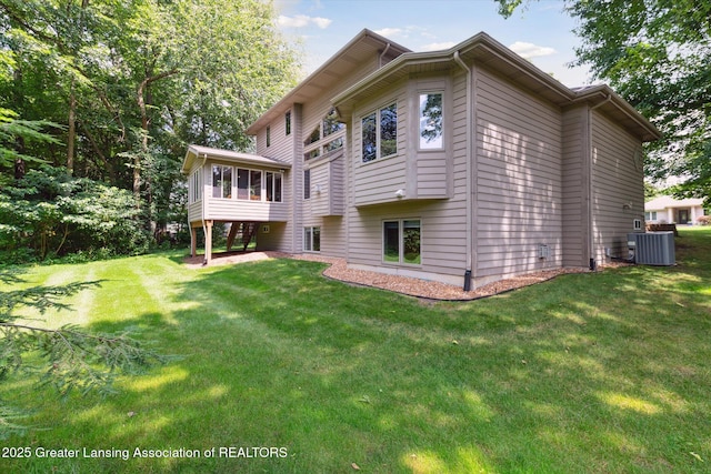 rear view of property with a sunroom, a lawn, and central air condition unit