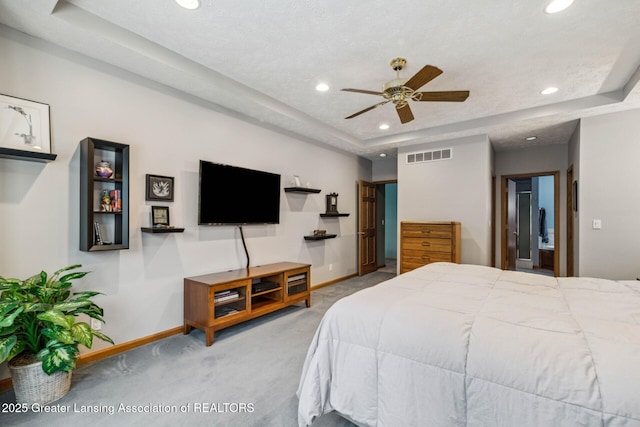 bedroom with carpet floors and a raised ceiling