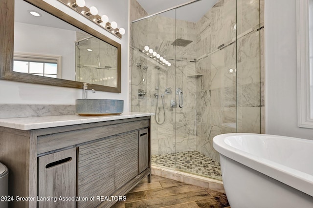 bathroom featuring vanity, wood-type flooring, and shower with separate bathtub