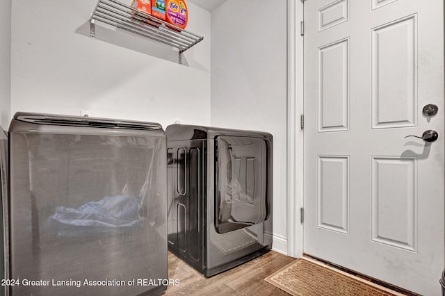 washroom with washer and clothes dryer and light wood-type flooring