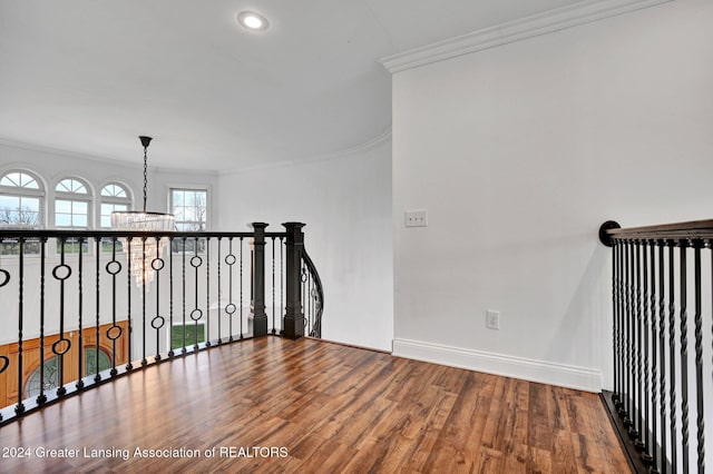 interior space with ornamental molding, hardwood / wood-style floors, and a notable chandelier