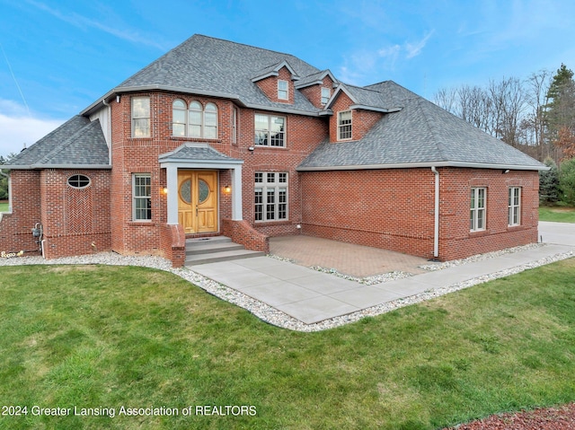 view of front of house with a front yard and a patio area