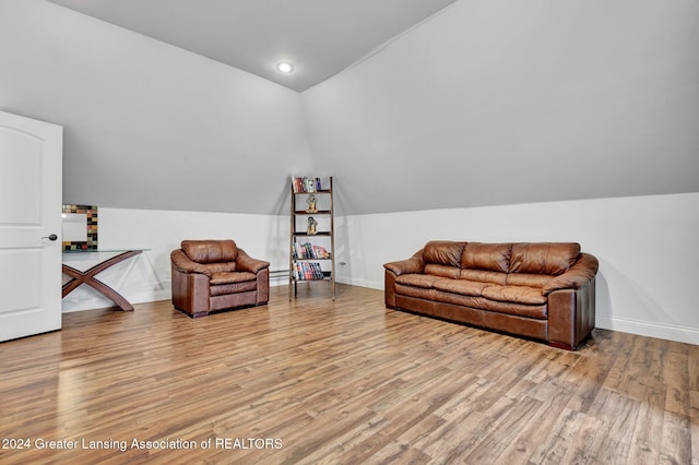 living area featuring lofted ceiling and light hardwood / wood-style floors