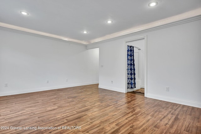 spare room featuring ornamental molding and light hardwood / wood-style flooring