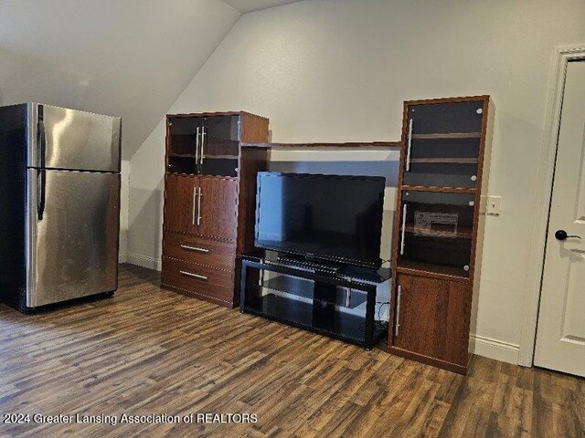 unfurnished living room featuring lofted ceiling and dark wood-type flooring