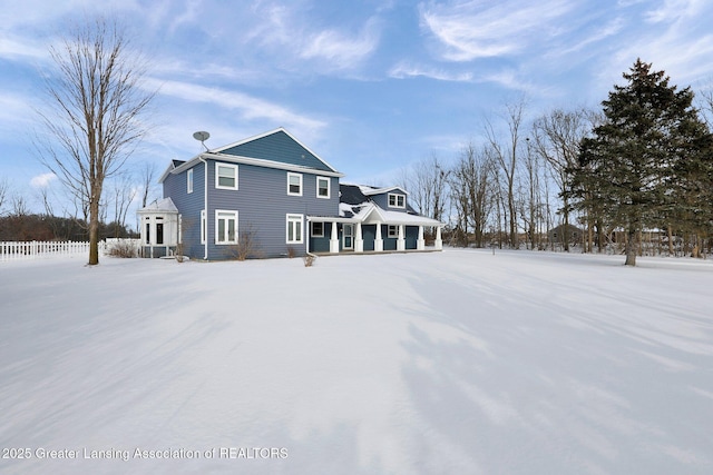 view of snow covered back of property