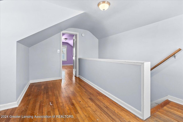 additional living space featuring vaulted ceiling and hardwood / wood-style flooring