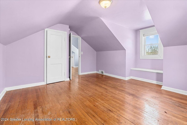 additional living space with lofted ceiling and wood-type flooring