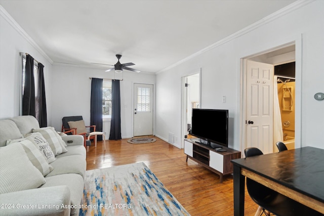 living room with ceiling fan, wood-type flooring, and crown molding