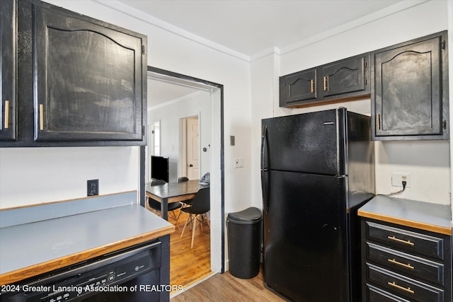 kitchen featuring crown molding, black appliances, and light wood-type flooring