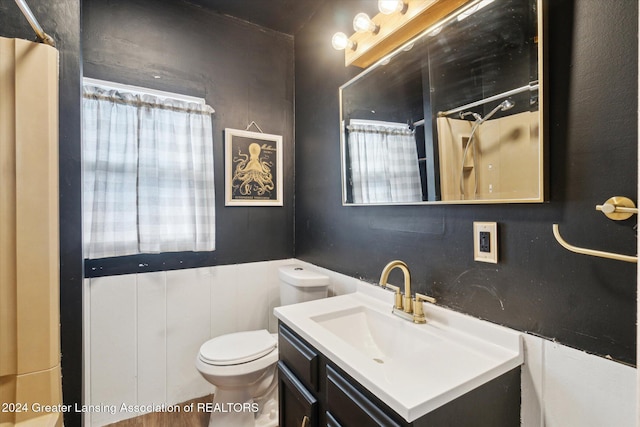 bathroom with curtained shower, toilet, and vanity