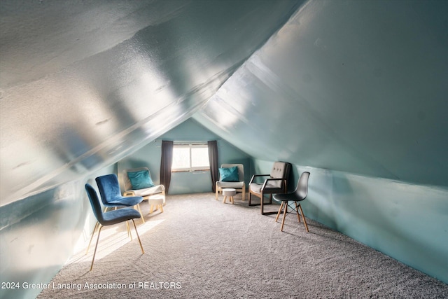 living area with carpet and vaulted ceiling