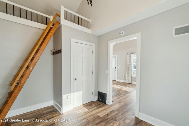 interior space with dark wood-type flooring and a high ceiling