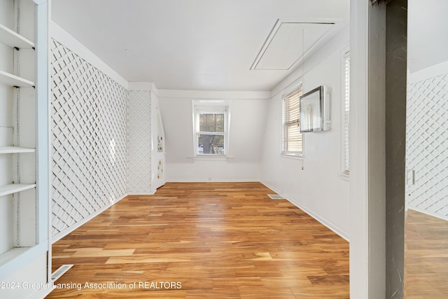 empty room with built in features and light hardwood / wood-style flooring