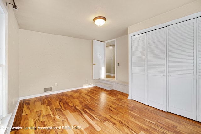 unfurnished bedroom featuring a closet and light hardwood / wood-style flooring